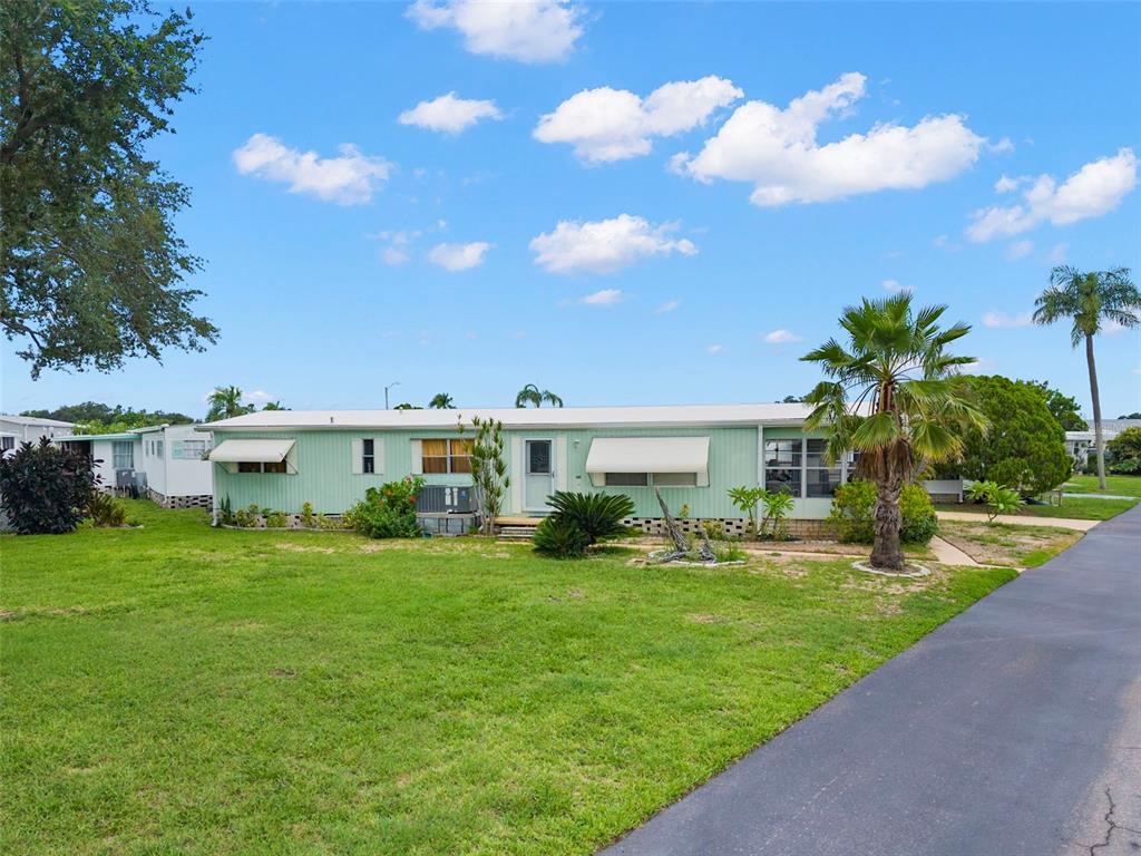 An aerial view shows a mobile home community situated along a waterfront with boat docks — 684 MOUNT LANCASTER AVENUE NE UNIT 644, ST PETERSBURG, FL