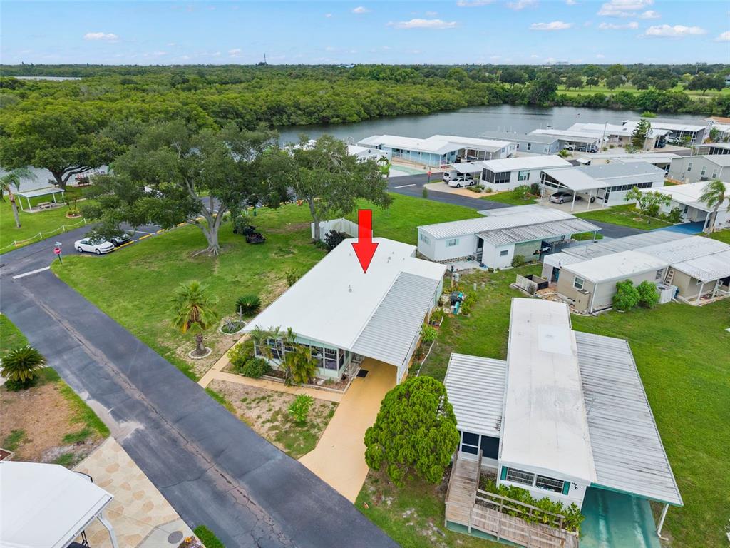 A light green single-story mobile home sits on a grassy lot with a paved driveway — 684 MOUNT LANCASTER AVENUE NE UNIT 644, ST PETERSBURG, FL