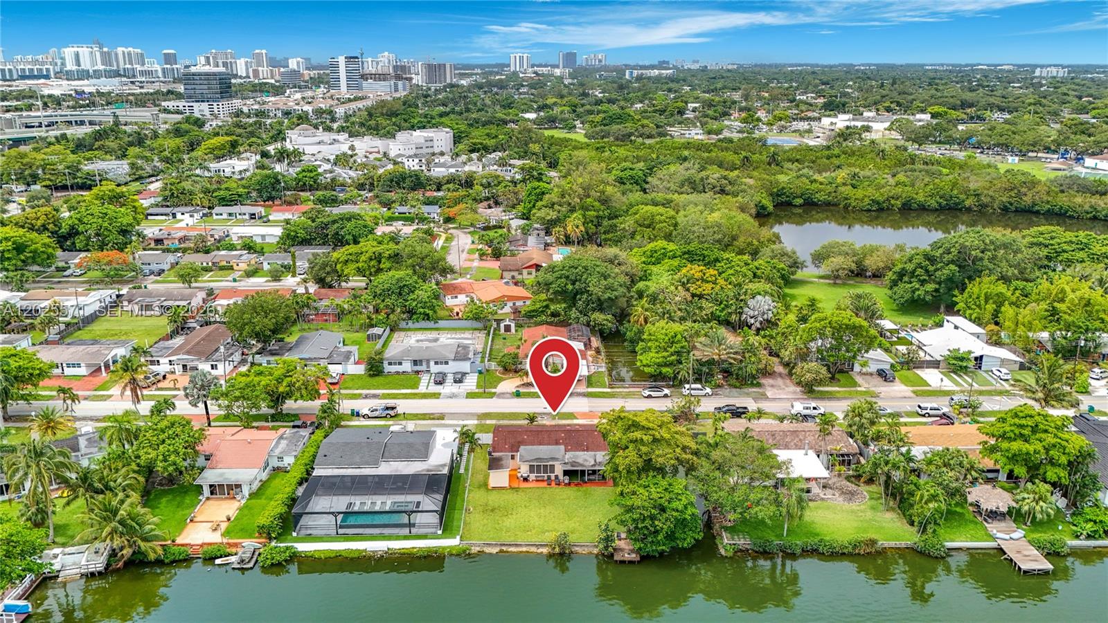 An aerial view shows a waterfront house with a pool and a red map pin — 2501 NE 209th Ter, Miami FL 33180, MIAMI, FL