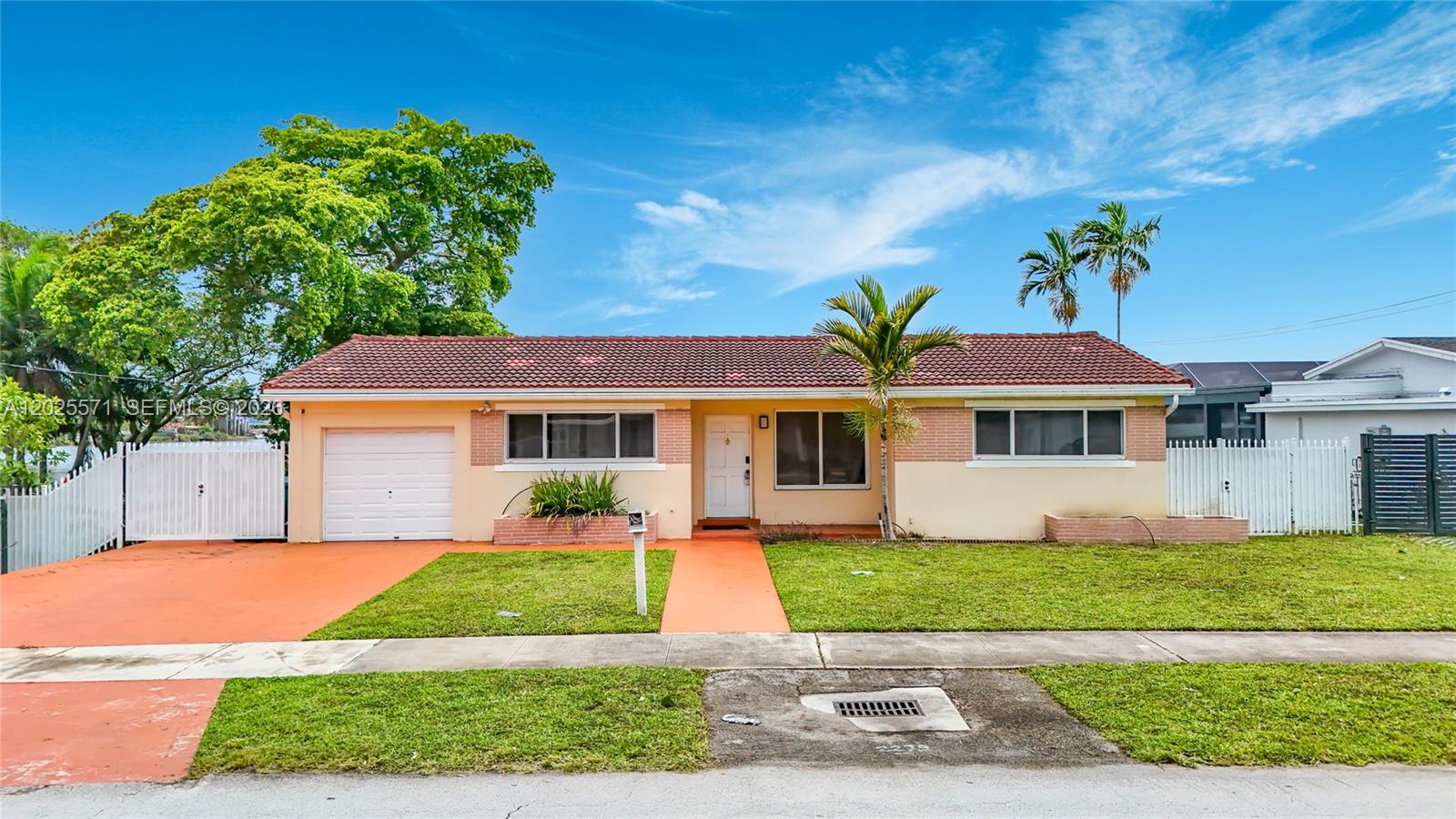 A single-story house with a red tile roof, brick accents, and a front lawn — 2501 NE 209th Ter, Miami FL 33180, MIAMI, FL