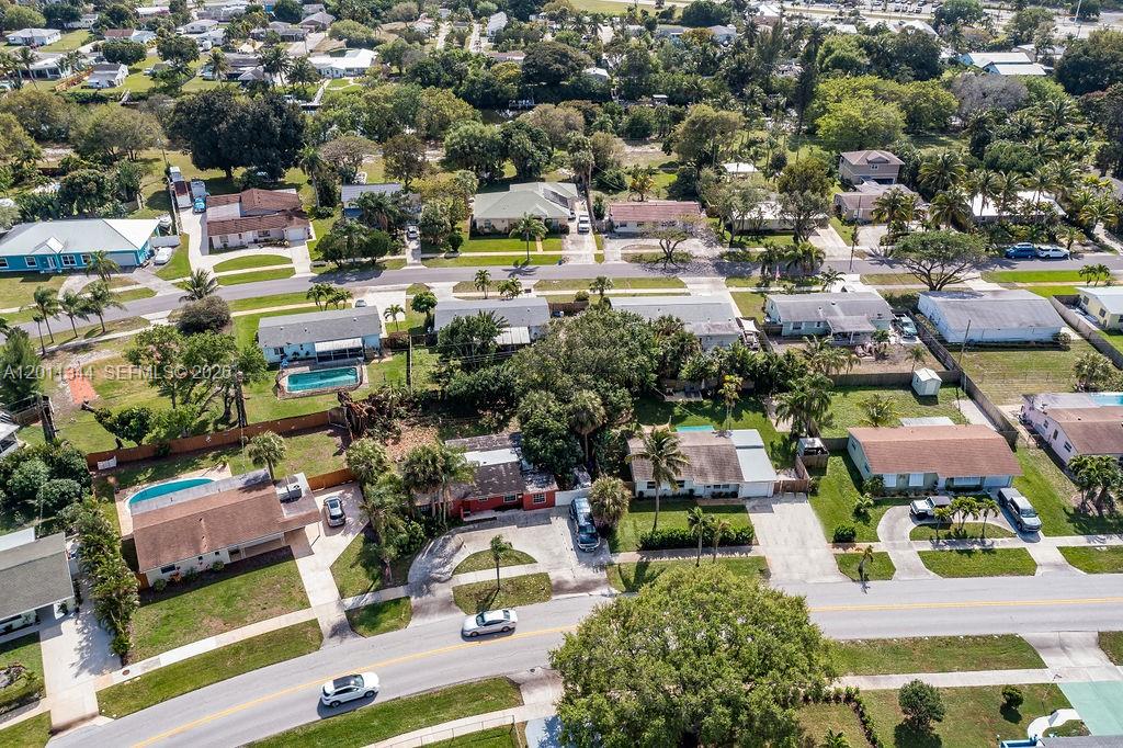 An aerial view shows a suburban neighborhood with single-family homes, swimming pools, and mature trees — 913 Lighthouse Dr, North Palm Beach FL 33408, NORTH PALM BEACH, FL