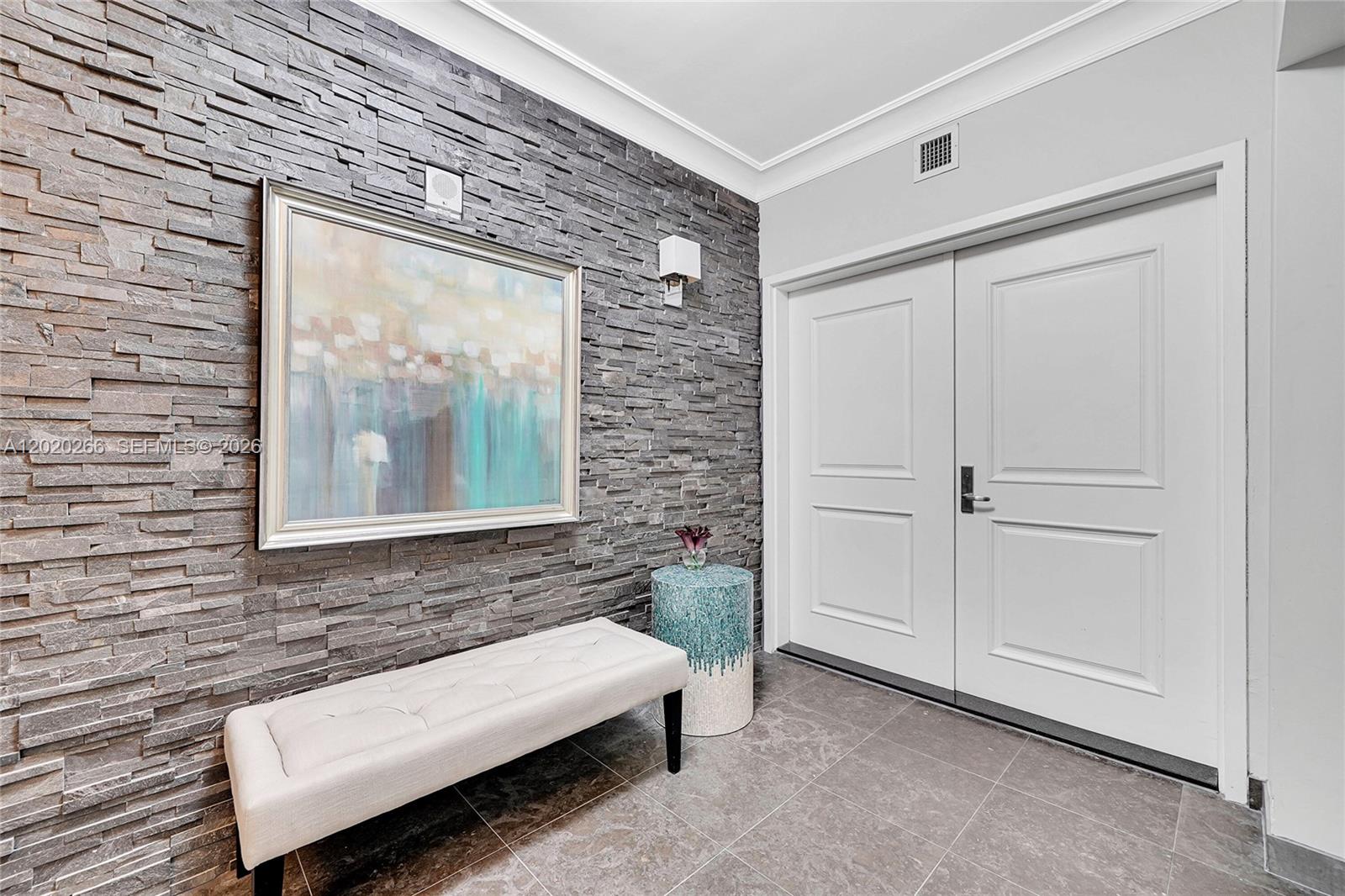 An entryway features a stone accent wall, a tufted bench, and double white doors — 3101 S Ocean Dr # 701, Hollywood FL 33019, HOLLYWOOD, FL