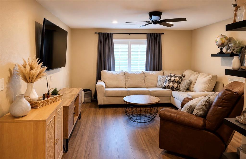 A living room features a sectional sofa, a brown leather recliner, and a television — 14836 55TH WAY N, CLEARWATER, FL