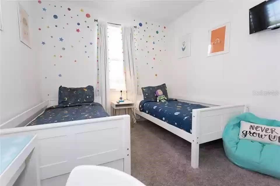 A bedroom features two twin beds with space-themed bedding and a teal beanbag chair — 134 CAPTIVA DRIVE, DAVENPORT, FL