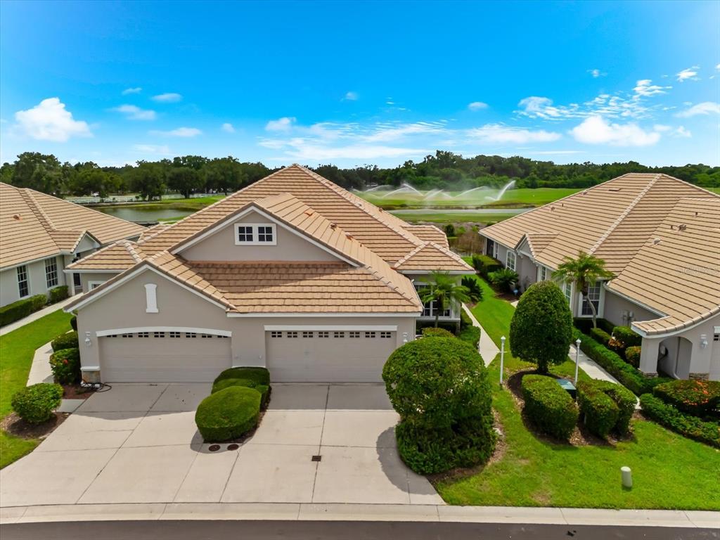 An aerial view of a suburban house with a tan tile roof and two-car garage — 6942 WOODMORE TERRACE, LAKEWOOD RANCH, FL