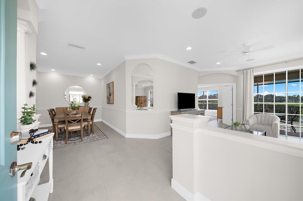 An open-concept dining and living area features light tile flooring and neutral wall colors — 6942 WOODMORE TERRACE, LAKEWOOD RANCH, FL