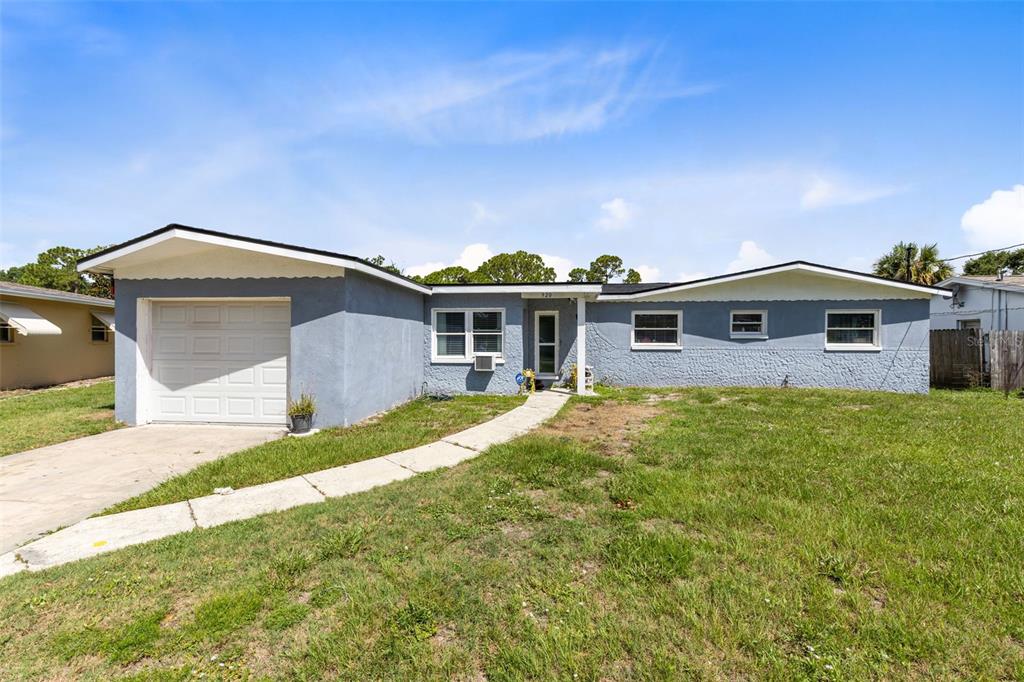 A single-story blue house with a white garage door and a concrete walkway — 920 GARDEN ROAD, MERRITT ISLAND, FL