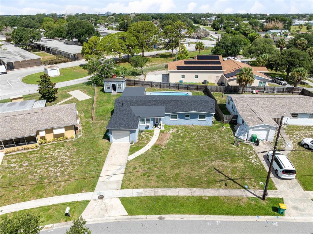 An aerial view shows a single-story house with a pool, garage, and large front yard — 920 GARDEN ROAD, MERRITT ISLAND, FL