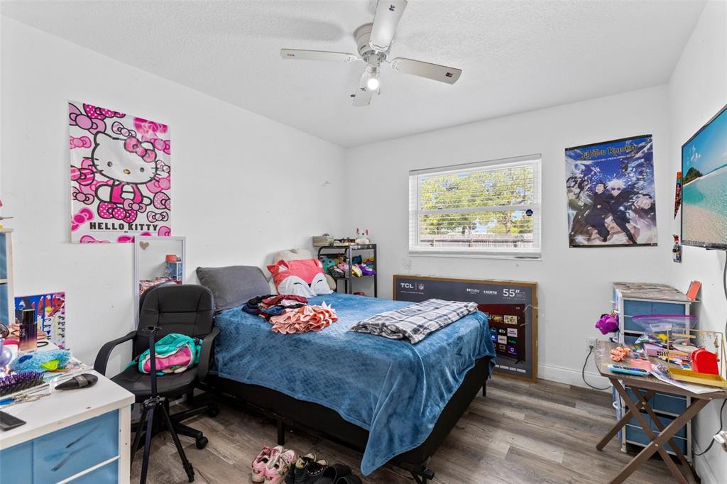 A bedroom features a bed, a desk, a ceiling fan, and wall posters — 920 GARDEN ROAD, MERRITT ISLAND, FL