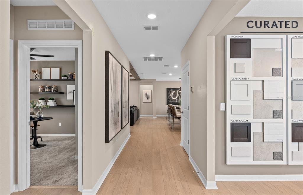 A hallway with light wood flooring leads past a side room and a design sample board — 10740 LEAFY LAUREL STREET, ORLANDO, FL