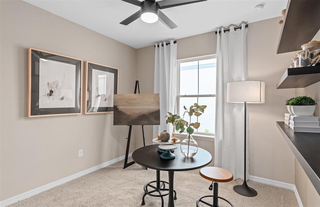A home office features a round table, an artist's easel, and wall-mounted shelving — 10740 LEAFY LAUREL STREET, ORLANDO, FL
