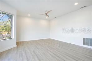 An empty room with light wood-look flooring, white walls, a ceiling fan, and a window — 5407 HANSEL AVENUE UNIT G12, ORLANDO, FL