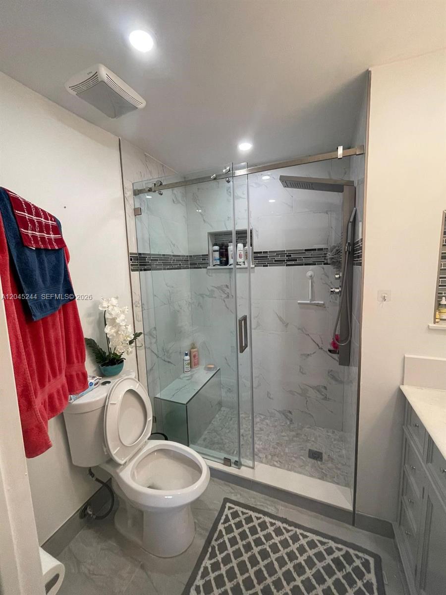 A bathroom features a glass-enclosed walk-in shower with marble-style tile and a toilet — 13302 SW 152nd St # 3008, Miami FL 33177, MIAMI, FL