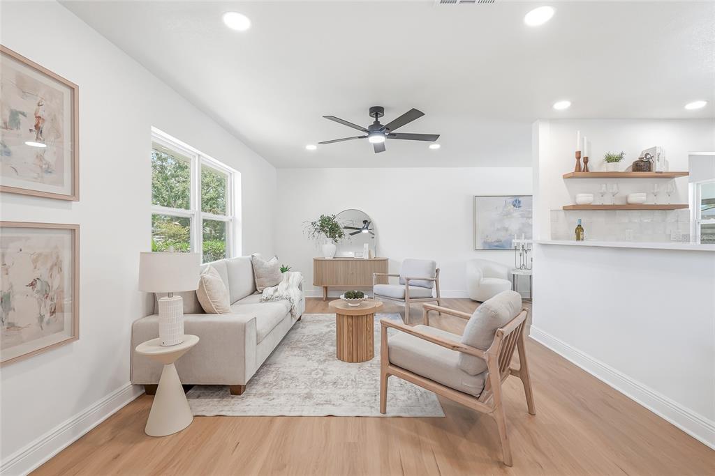 A view from a hallway into a living room and a kitchen with light flooring — 5116 18TH AVENUE W, BRADENTON, FL