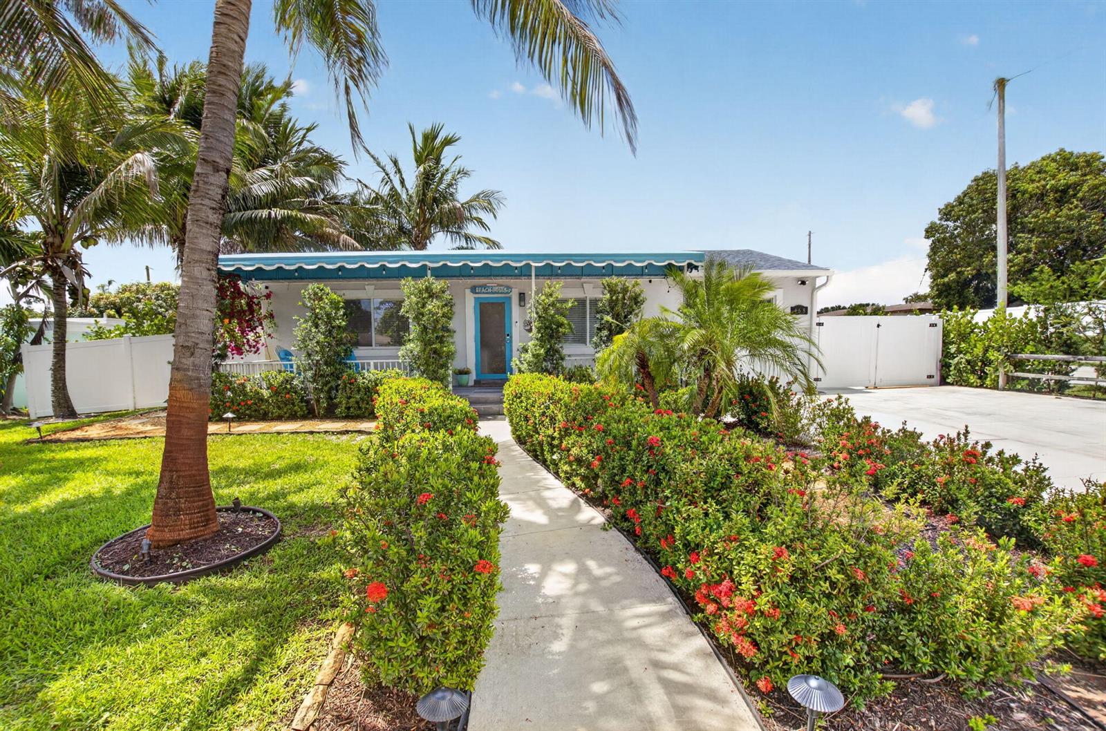 A single-story house with a blue awning and a walkway lined with flowering hedges — 468 W Ocean Avenue, Boynton Beach FL 33435, BOYNTON BEACH, FL