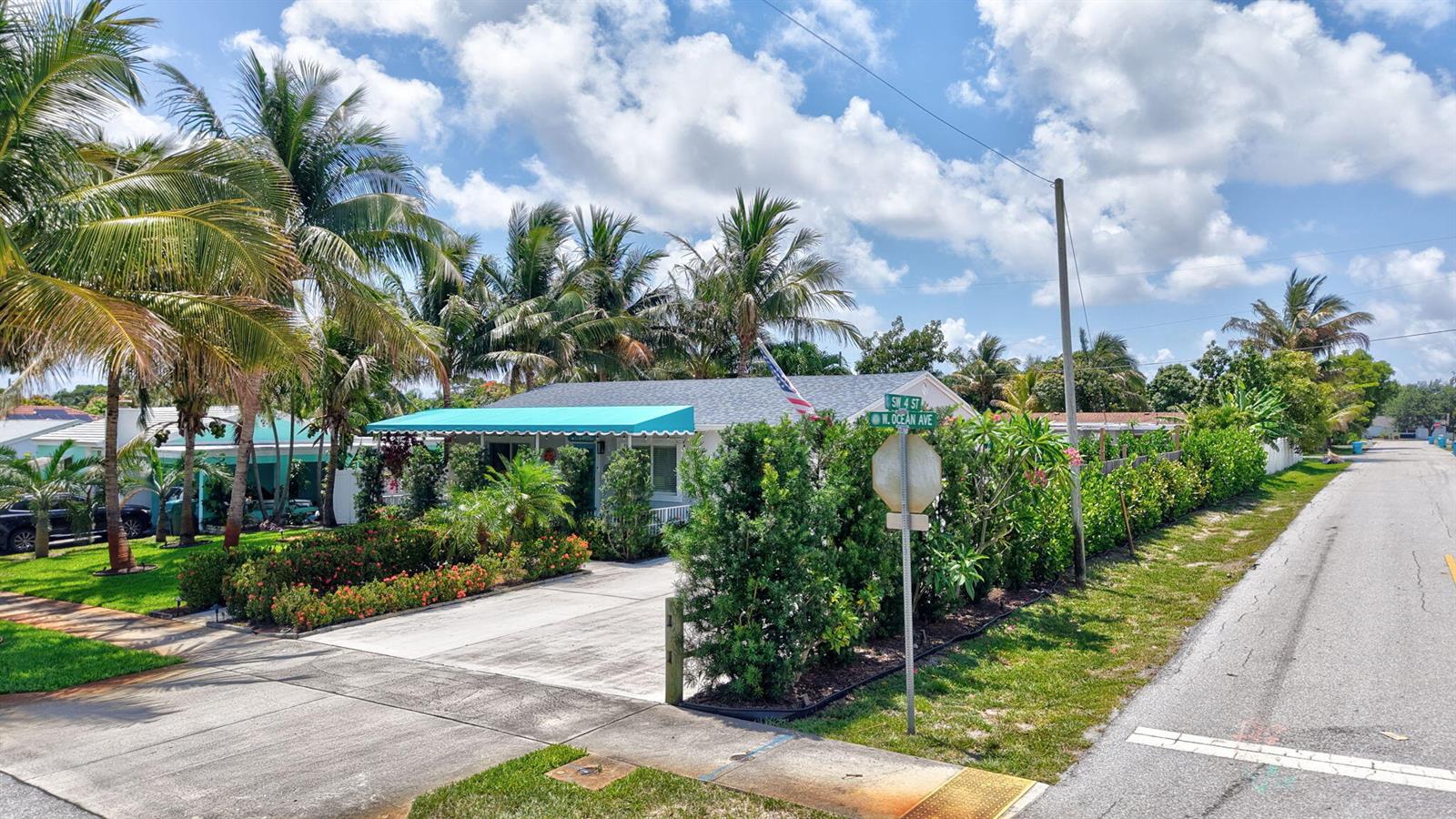 A single-story house with a turquoise awning sits on a corner lot with palm trees — 468 W Ocean Avenue, Boynton Beach FL 33435, BOYNTON BEACH, FL