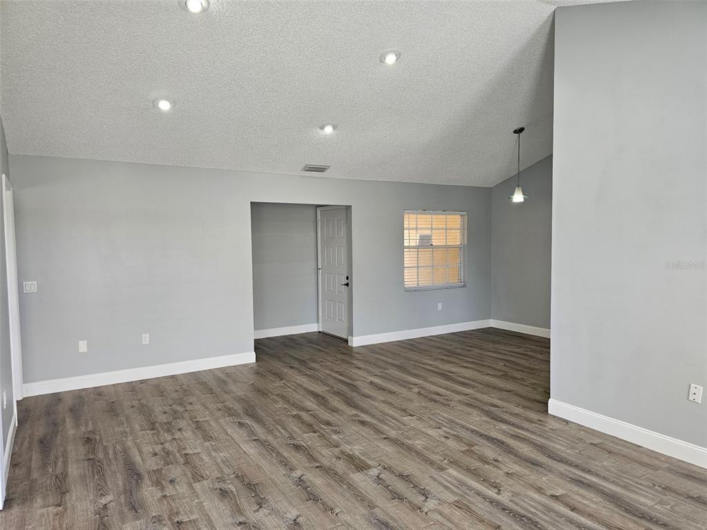 A living room with gray walls, recessed lighting, and wood-look flooring — 3625 57TH AVENUE DRIVE W, BRADENTON, FL