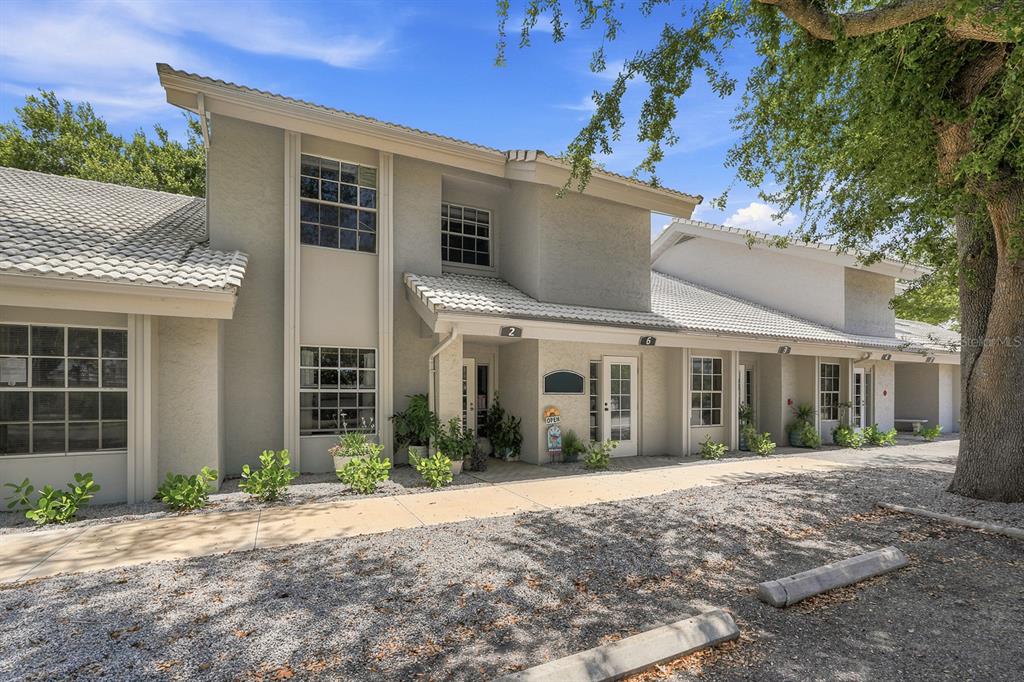 A two-story commercial building with a gravel parking area and a concrete walkway — 1515 TAMIAMI TRAIL S UNIT 2A, VENICE, FL