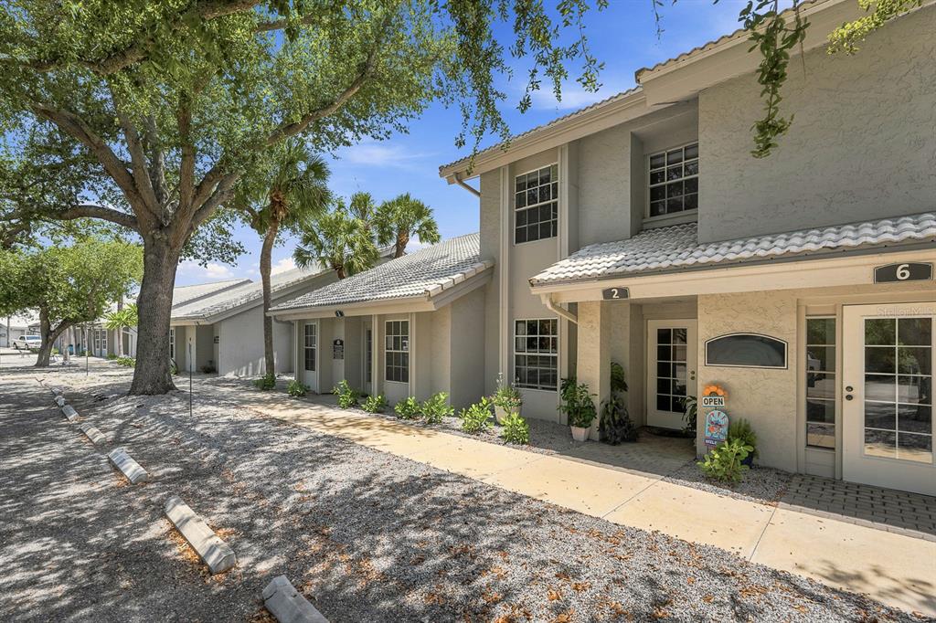 A two-story commercial building with a gravel parking area and a concrete walkway — 1515 TAMIAMI TRAIL S UNIT 2A, VENICE, FL