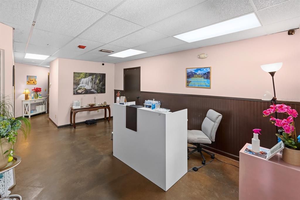 A reception area features a white desk, a gray office chair, and brown wainscoting — 1515 TAMIAMI TRAIL S UNIT 2A, VENICE, FL
