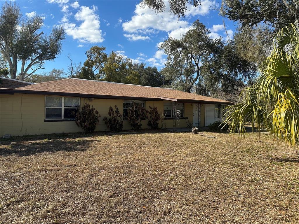 A single-story house with yellow siding and a brown shingled roof sits on a lawn — 2220 N GALLOWAY ROAD, LAKELAND, FL