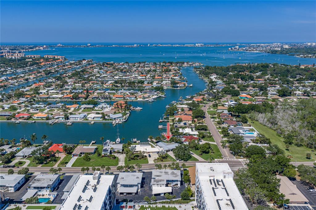 An aerial view shows a waterfront residential property with a red arrow pointing to the house — 4201 37TH STREET S, ST PETERSBURG, FL