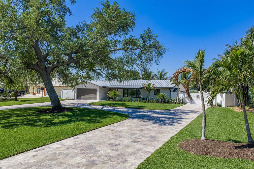 A single-story house with a metal roof and paved driveway sits on a grassy lot — 4201 37TH STREET S, ST PETERSBURG, FL