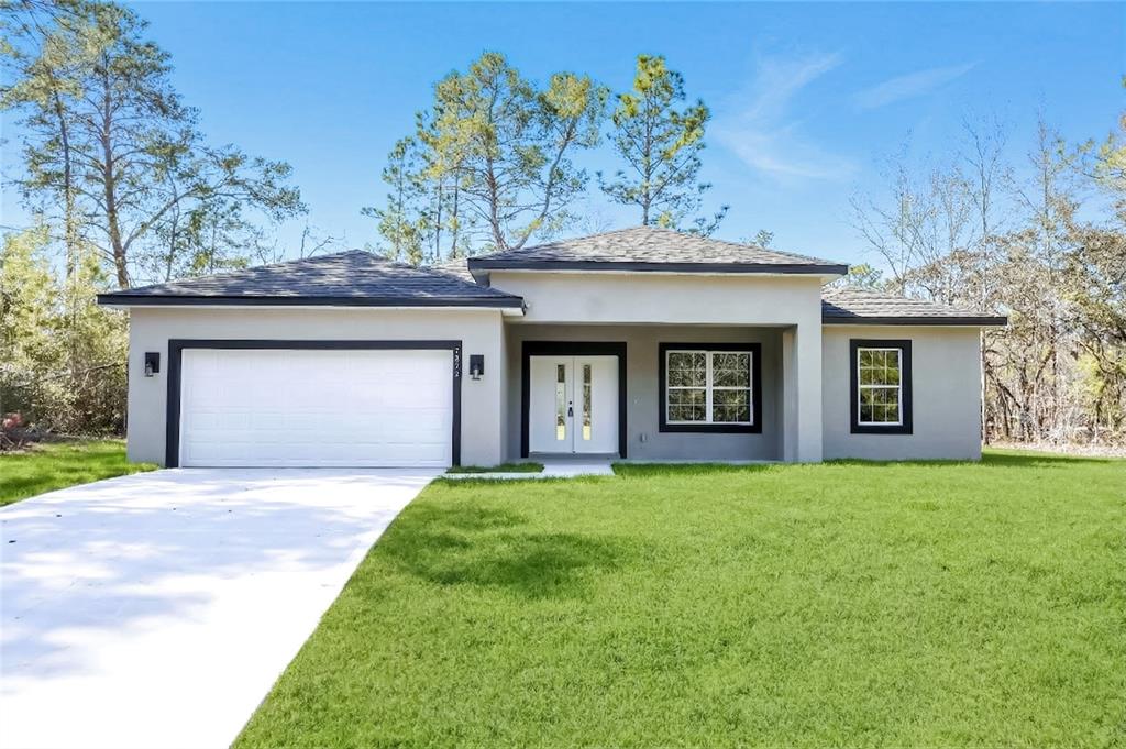 A single-story house with a white garage, double front doors, and a grassy front yard — 7872 N KEYSTONE DRIVE, CITRUS SPRINGS, FL