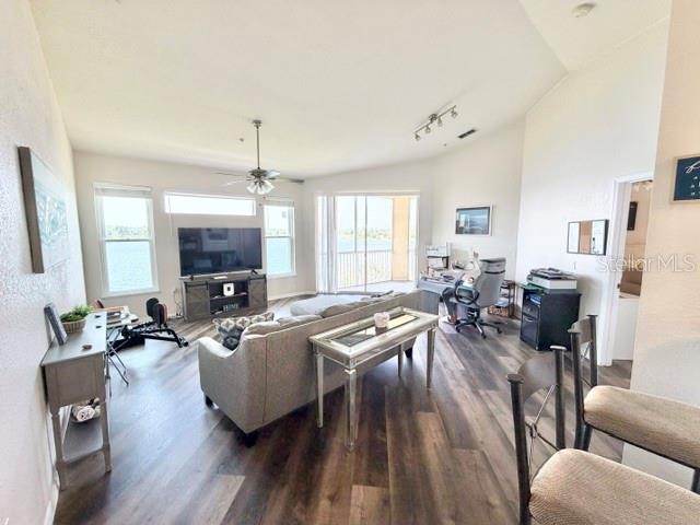 A living room features wood-look flooring, a grey sofa, a television console, and a balcony — 1408 LAKE SHADOW CIRCLE UNIT 1308, MAITLAND, FL