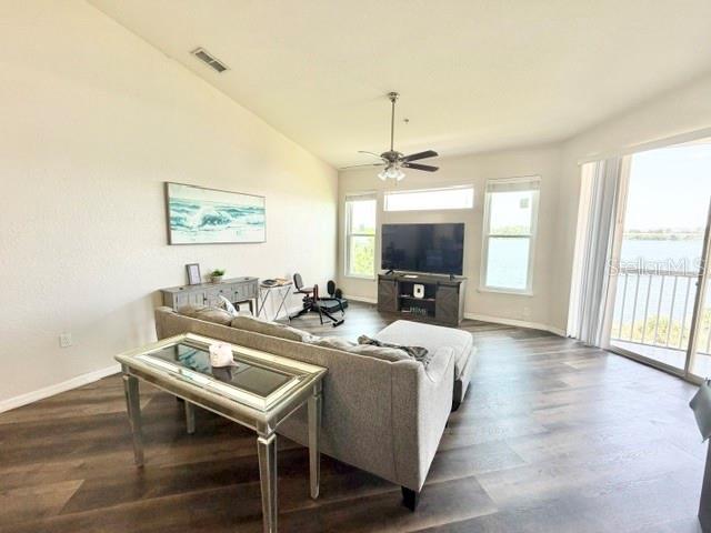 A living room features a gray sofa, a glass-topped side table, and a balcony view — 1408 LAKE SHADOW CIRCLE UNIT 1308, MAITLAND, FL