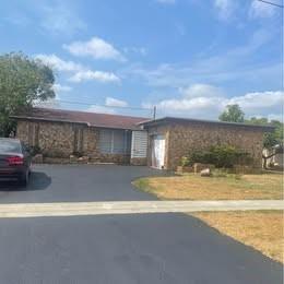 A single-story brick house with a dark asphalt driveway and a car parked on the left — 12030 NW 29th Manor, Sunrise FL 33323, SUNRISE, FL
