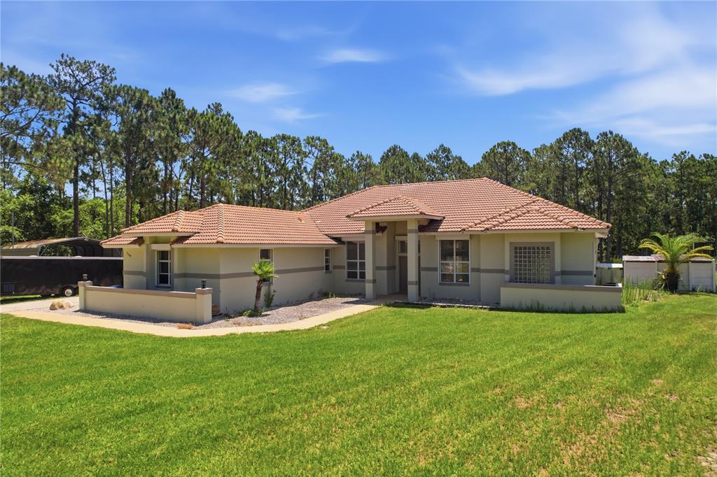 A single-story house with a tiled roof and a front lawn under a blue sky — 7190 SIX GUN COURT, ST CLOUD, FL
