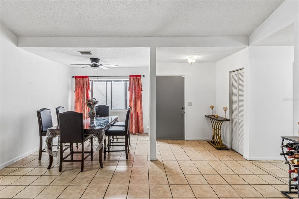 A dining area with tile floors, a dark table with chairs, and a gray door — 271 MARIPOSA, WINTER HAVEN, FL