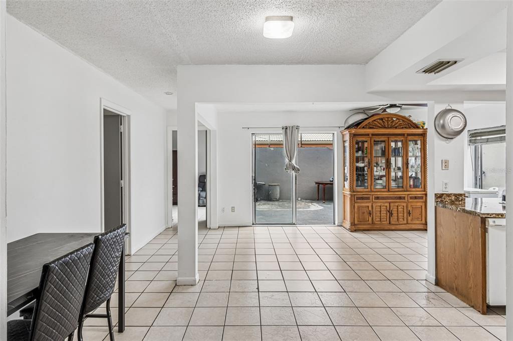 A dining area with tile floors leads to a sliding glass door opening onto a patio — 271 MARIPOSA, WINTER HAVEN, FL