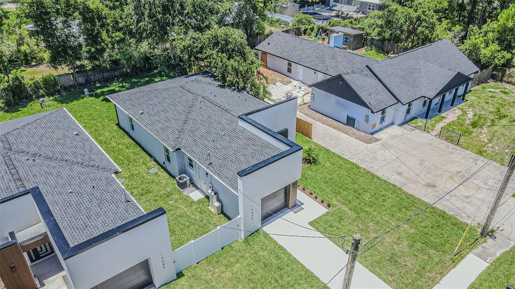 An aerial view shows two modern houses with gray roofs and white walls on a lot — 12690 N CENTRAL AVENUE, TAMPA, FL