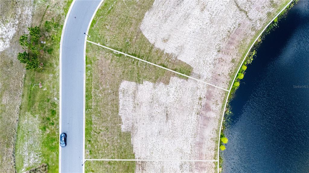 An aerial view shows a vacant residential lot situated between a paved road and water — LOT 36, CROMWELL ROAD, ORLANDO, FL