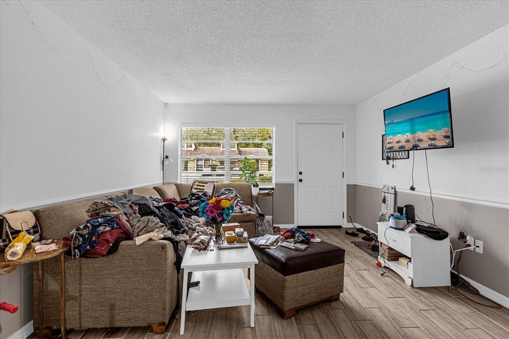 A living room features a large sectional sofa, a coffee table, and a wall-mounted television — 1267 WOODMAN WAY, ORLANDO, FL