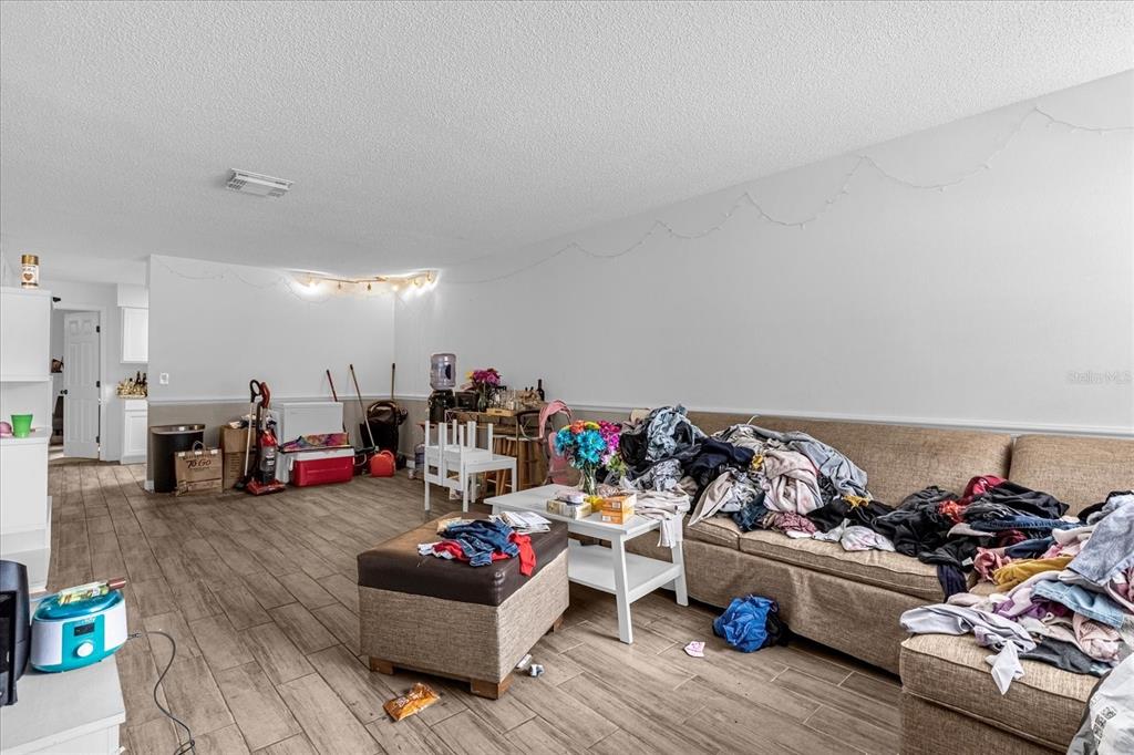A living room with tile flooring, a large beige sofa, and a coffee table — 1267 WOODMAN WAY, ORLANDO, FL