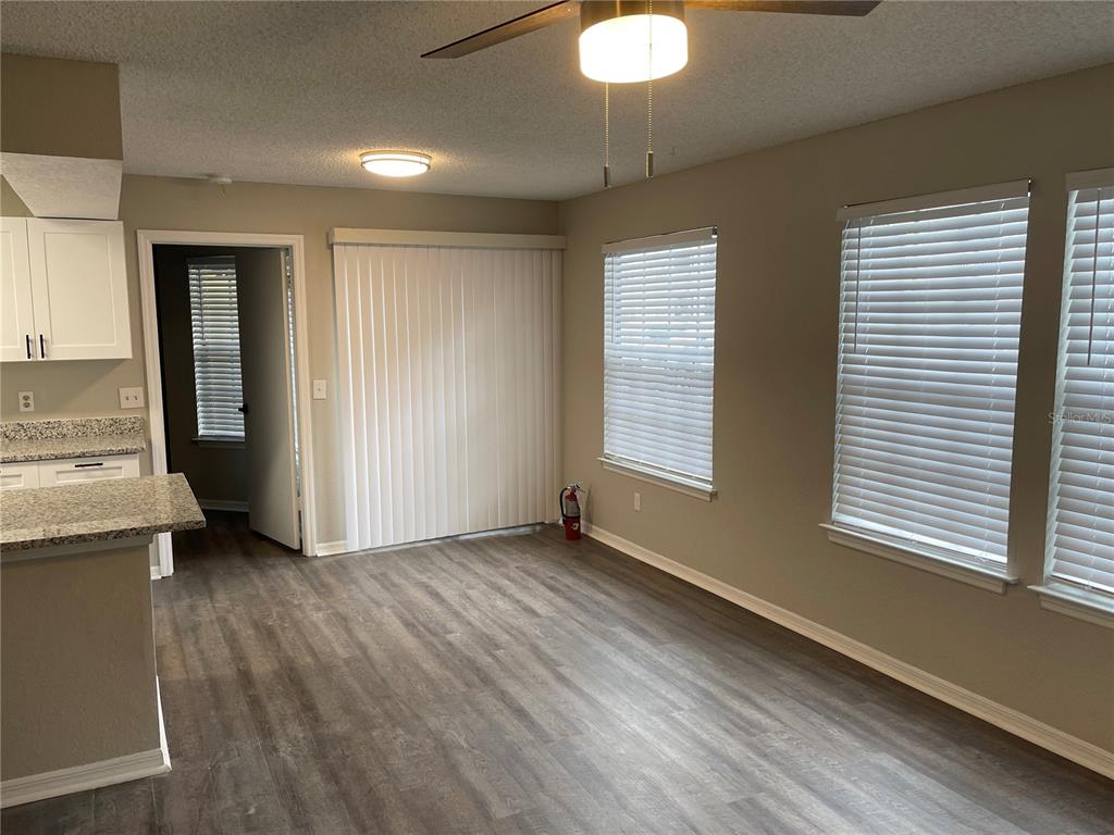 A dining area with wood-look flooring, white blinds, a ceiling fan, and a sliding glass door — 1027 S HIAWASSEE ROAD UNIT 2311, ORLANDO, FL