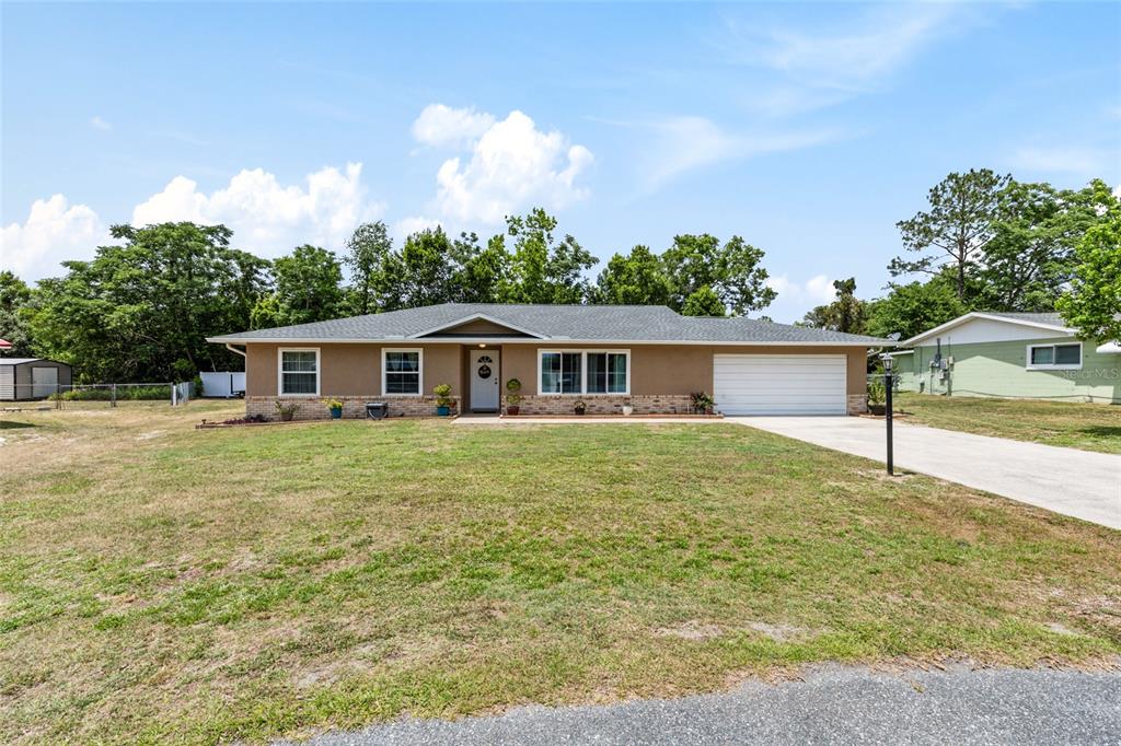 A single-story house with a tan exterior, brick accents, and an attached two-car garage — 5 SILVER RUN, OCALA, FL