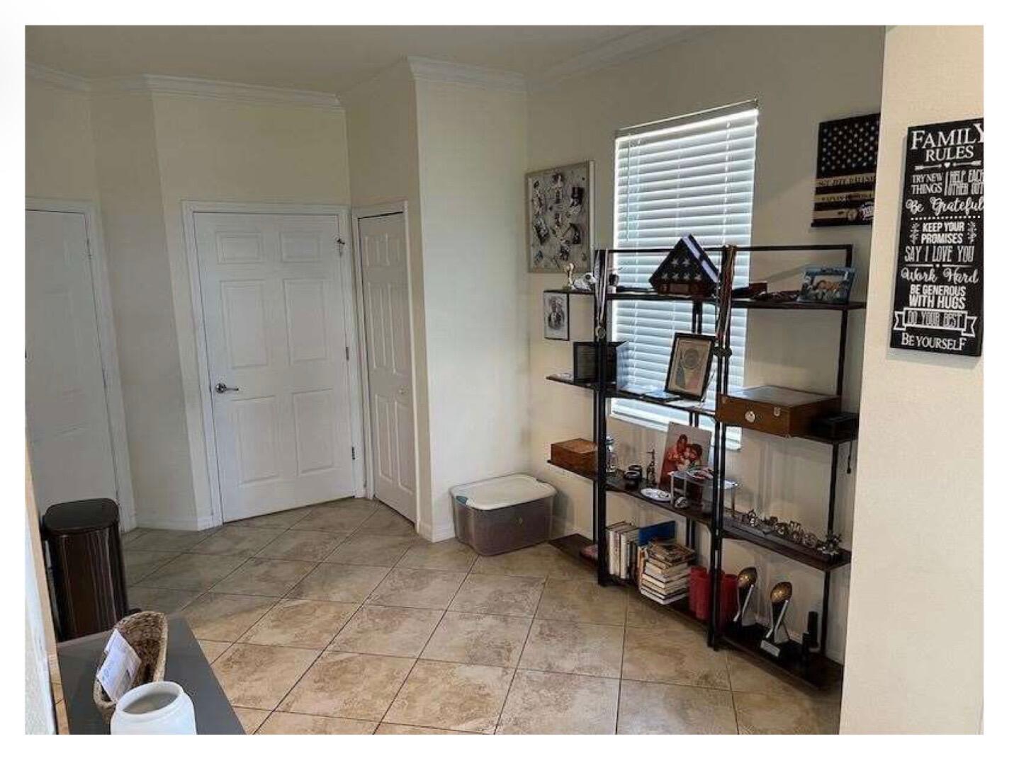 A tiled entryway features a tall metal shelving unit, a white door, and wall decor — 2763 Citrus Street, Naples FL 34120, NAPLES, FL