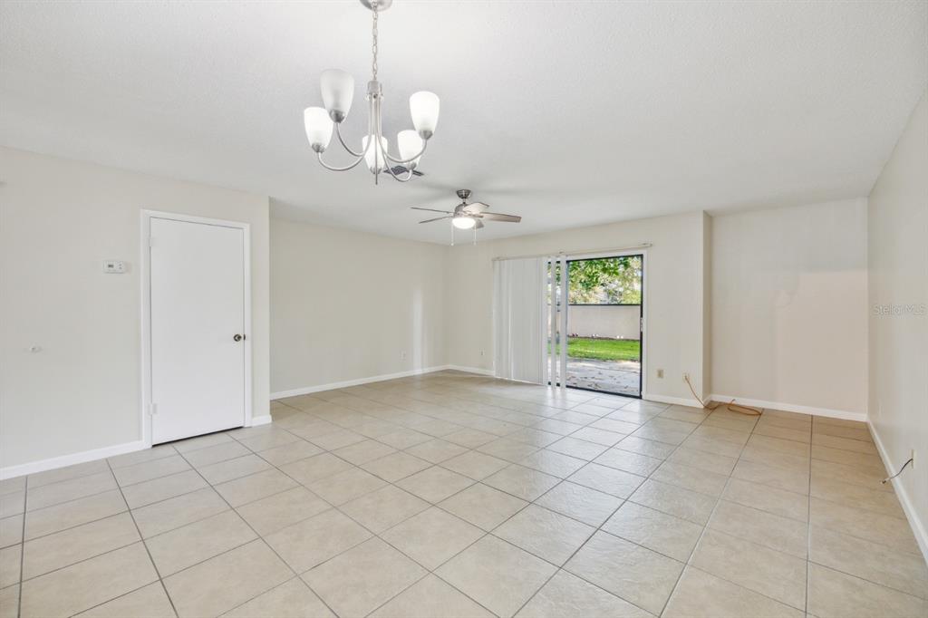 A spacious living room features light-colored tile flooring, a ceiling fan, and a sliding glass door — 2748 CANDLEWOOD COURT, APOPKA, FL