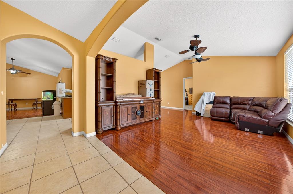 A living room features hardwood floors, yellow walls, a brown sectional sofa, and wood cabinetry — 300 VIKING ST NE, PALM BAY, FL
