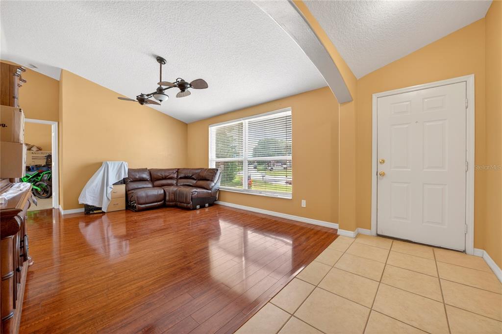 A living room features hardwood floors, a brown sectional sofa, and an adjacent tiled entryway — 300 VIKING ST NE, PALM BAY, FL