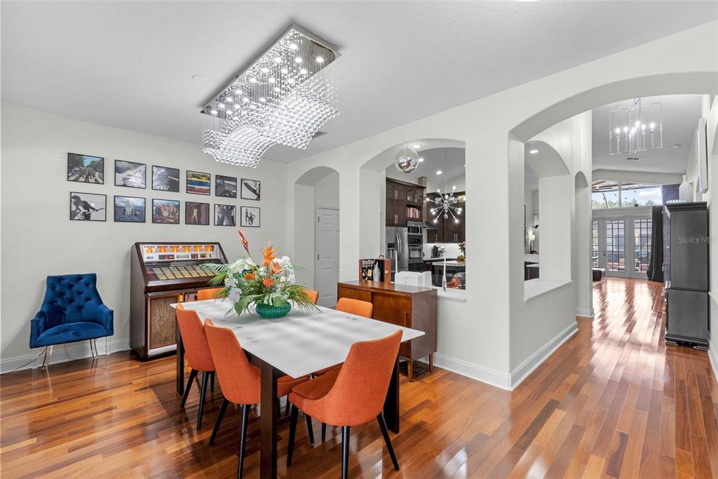 A dining room features orange chairs, a jukebox, and a modern crystal chandelier — 1536 ABYSS DRIVE, ODESSA, FL