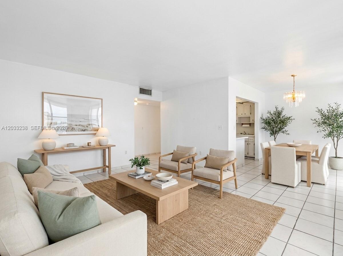 A living and dining area features white tile floors, neutral furniture, and a jute rug — 8001 Byron Ave # 3C, Miami Beach FL 33141, MIAMI BEACH, FL