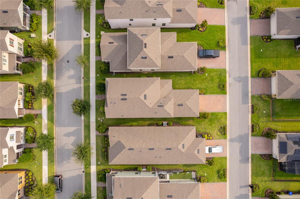 An aerial view shows several suburban houses with shingled roofs, driveways, and green lawns — 9445 KOMIKA LANE, WINTER GARDEN, FL