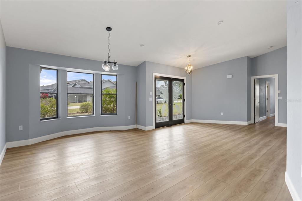 An empty room with light blue walls, wood-look flooring, a bay window, and glass doors — 751 E GILCHRIST COURT, HERNANDO, FL