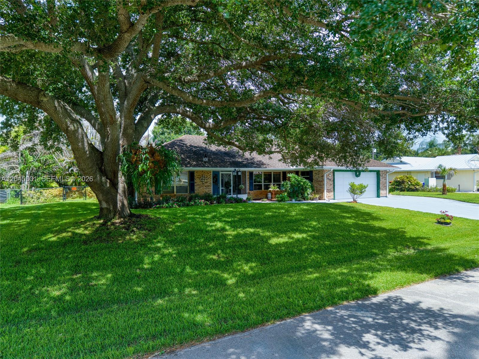 An aerial view of a single-story brick house with a two-car garage and driveway — 465 11th Ave, Vero Beach FL 32962, VERO BEACH, FL