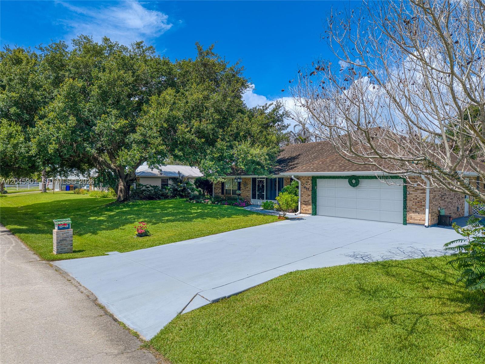 A single-story brick house with a large oak tree in the front yard — 465 11th Ave, Vero Beach FL 32962, VERO BEACH, FL
